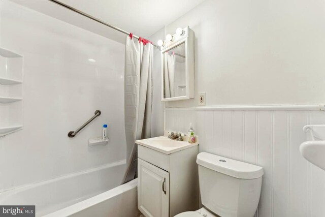 4600 Duke St Unit 1118, Alexandria, VA 22304 - full bath featuring toilet, shower / tub combo with curtain, a wainscoted wall, and vanity