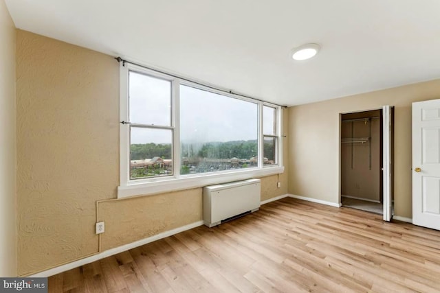 4600 Duke St Unit 1118, Alexandria, VA 22304 - unfurnished bedroom with radiator heating unit, baseboards, light wood-type flooring, and a closet