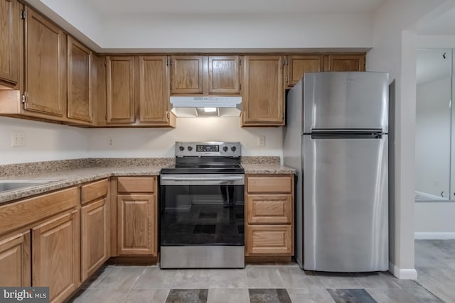 11409 Fruitwood Way Unit 163, Germantown, MD 20876 - kitchen with stainless steel appliances, under cabinet range hood, light countertops, and brown cabinetry