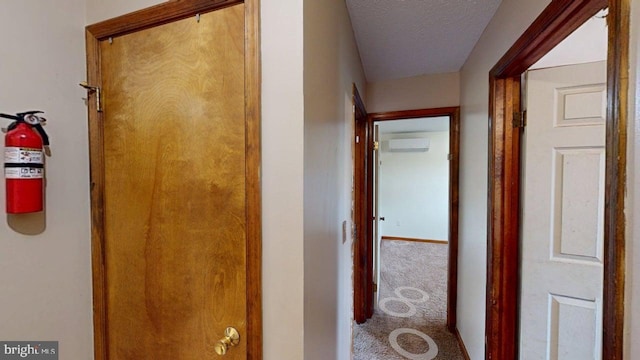521 E Rdg Loop Rd, Romney, WV 26757 - corridor featuring a wall mounted air conditioner, carpet, baseboards, and a textured ceiling