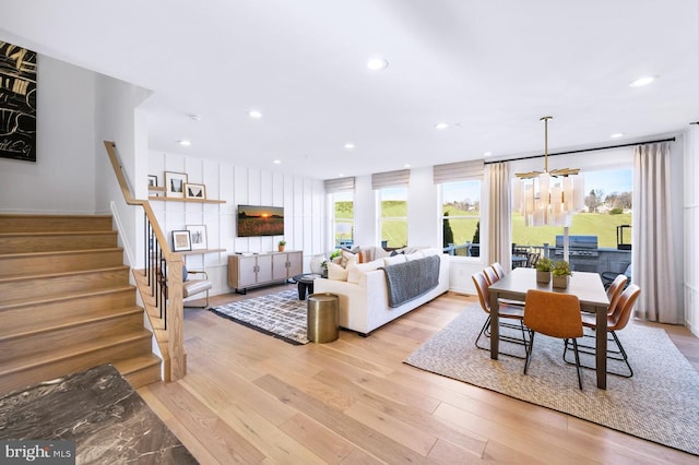 living area with recessed lighting, stairs, wood finished floors, and a chandelier