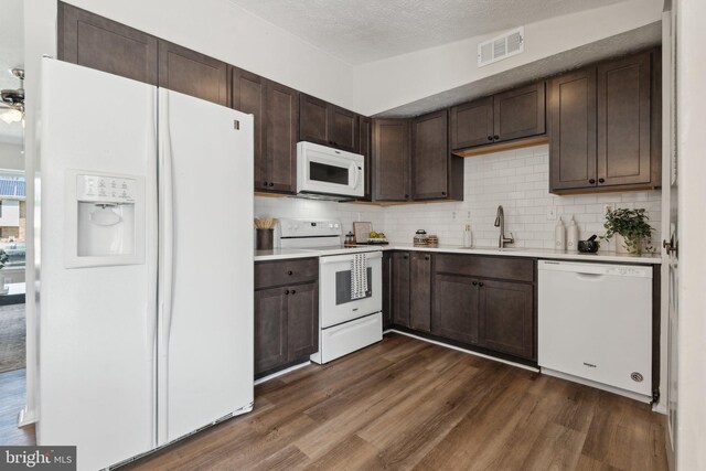 2963 Crystal Palace Ln, Pasadena, MD 21122 - kitchen with dark brown cabinets, white appliances, light countertops, a sink, and dark wood finished floors