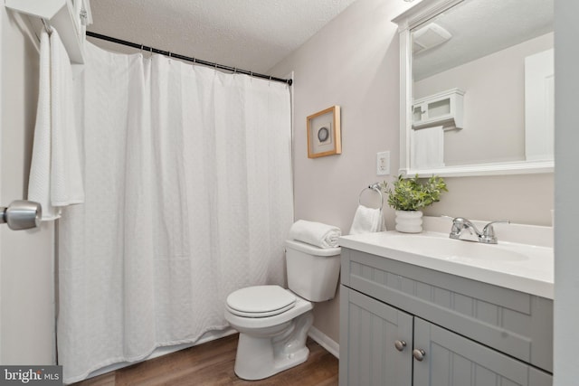 2963 Crystal Palace Ln, Pasadena, MD 21122 - bathroom with vanity, toilet, a textured ceiling, and wood finished floors