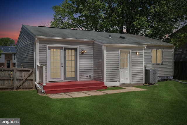2963 Crystal Palace Ln, Pasadena, MD 21122 - rear view of house featuring central air condition unit, a lawn, fence, and a shingled roof