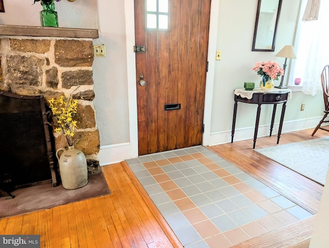 foyer entrance featuring baseboards and hardwood / wood-style flooring