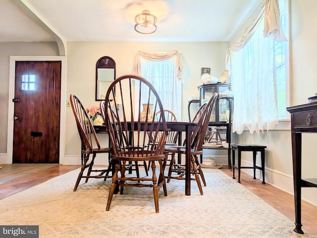 dining space with baseboards and wood finished floors