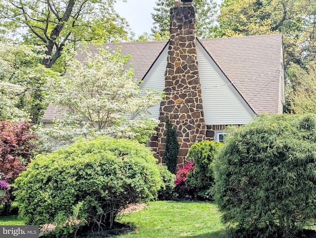 view of home's exterior featuring a lawn and a chimney