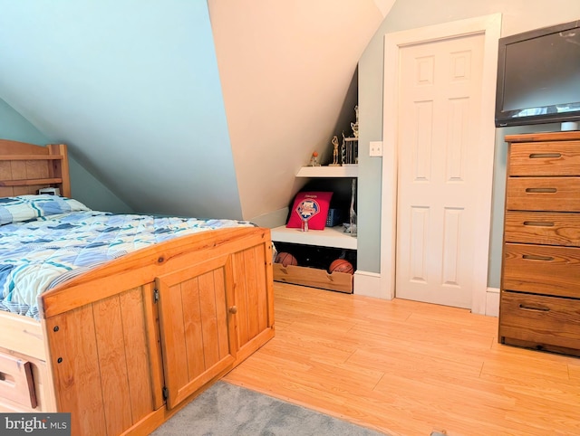 bedroom featuring light wood-type flooring and vaulted ceiling