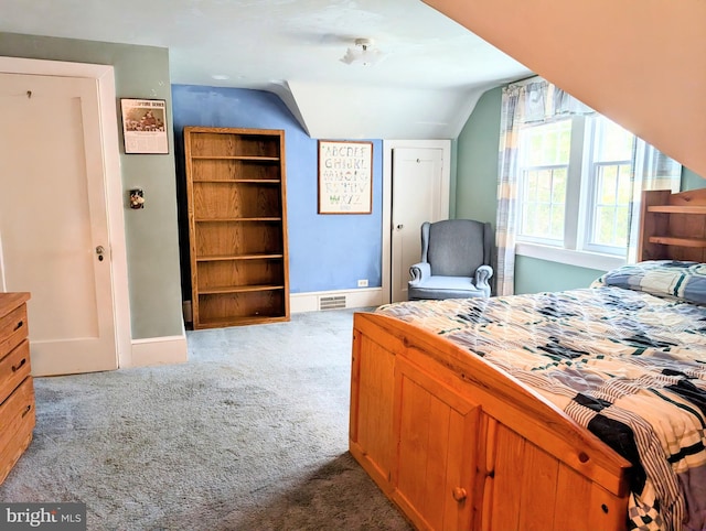 bedroom with visible vents, carpet flooring, baseboards, and vaulted ceiling