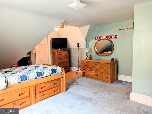 carpeted bedroom with baseboards and vaulted ceiling