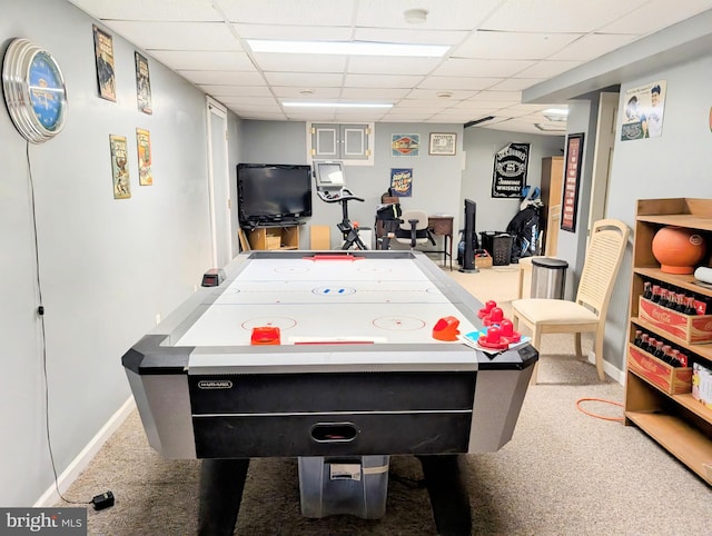 recreation room featuring carpet floors, baseboards, and a drop ceiling