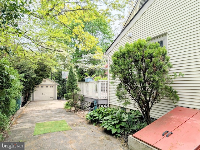 exterior space with an outbuilding, driveway, and a deck