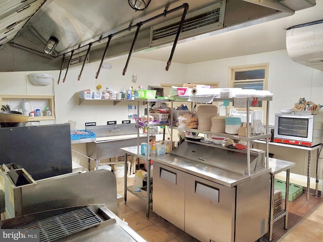 kitchen featuring light tile patterned floors and stainless steel countertops