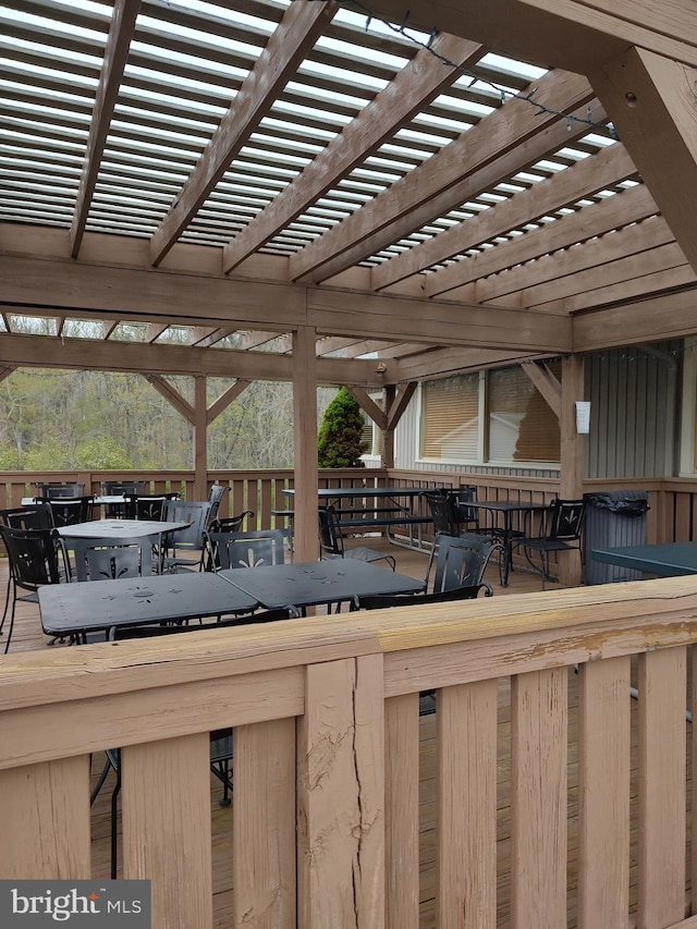deck featuring outdoor dining area and a pergola
