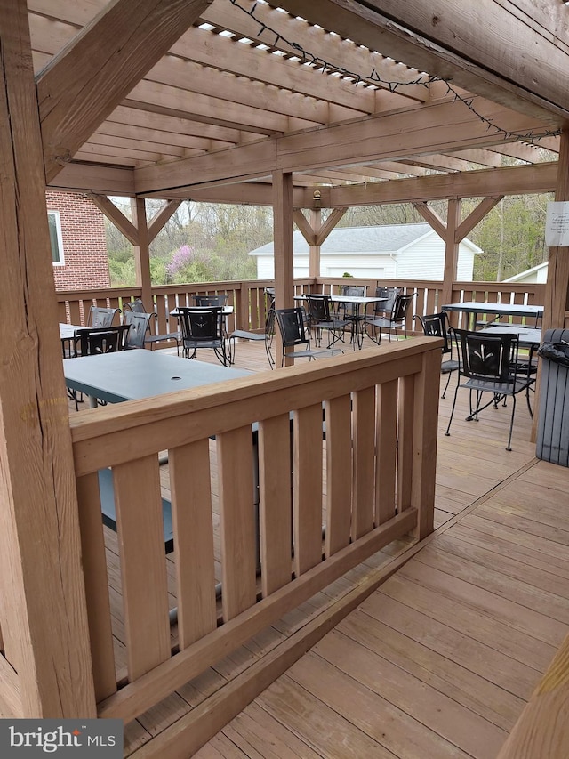 wooden terrace with a pergola and outdoor dining area