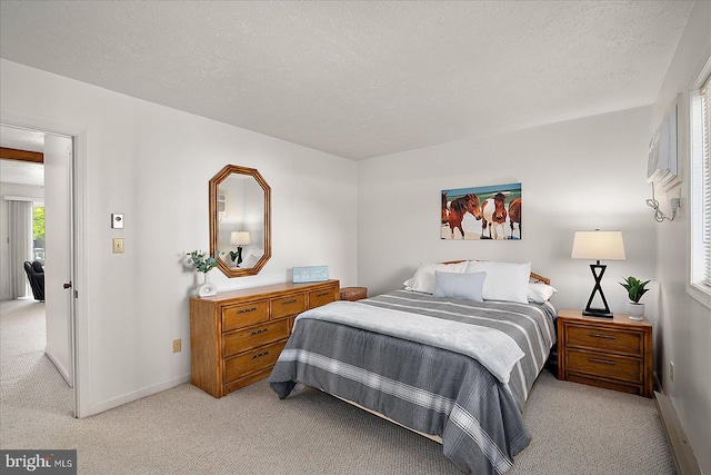 bedroom featuring baseboards, light carpet, and a textured ceiling
