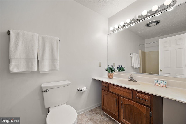 full bathroom with vanity, baseboards, toilet, and a textured ceiling