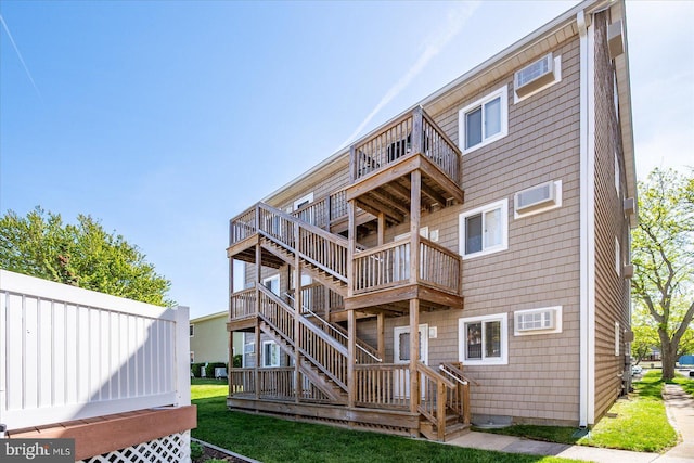 rear view of property featuring a yard and a balcony