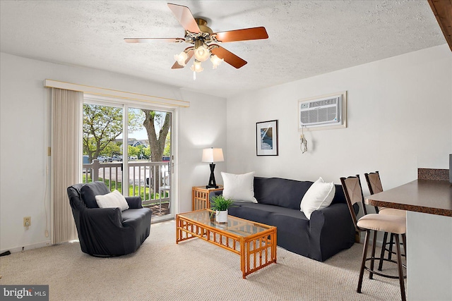 living area with carpet flooring, an AC wall unit, ceiling fan, and a textured ceiling