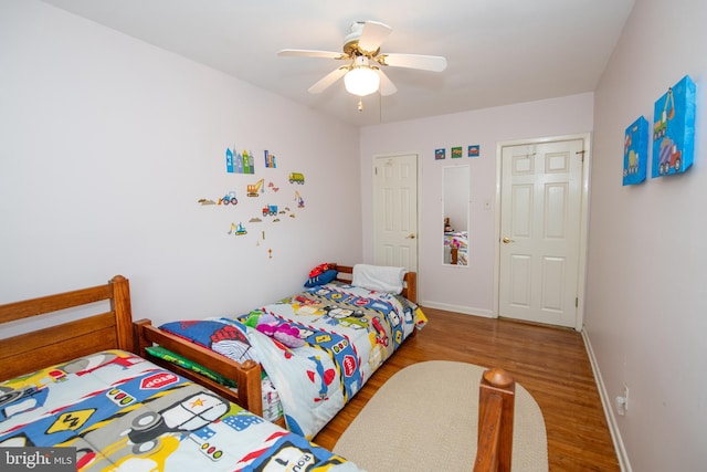 bedroom with ceiling fan, wood finished floors, and baseboards