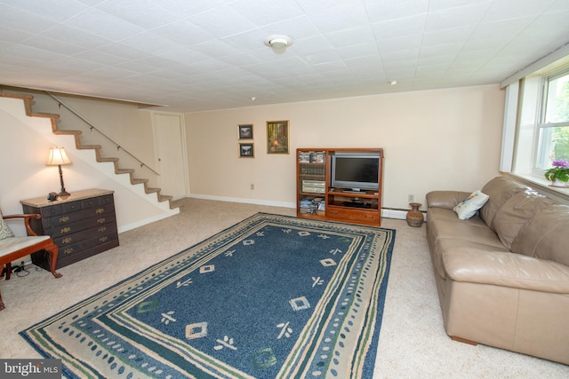 living room with a baseboard heating unit, stairs, and carpet floors