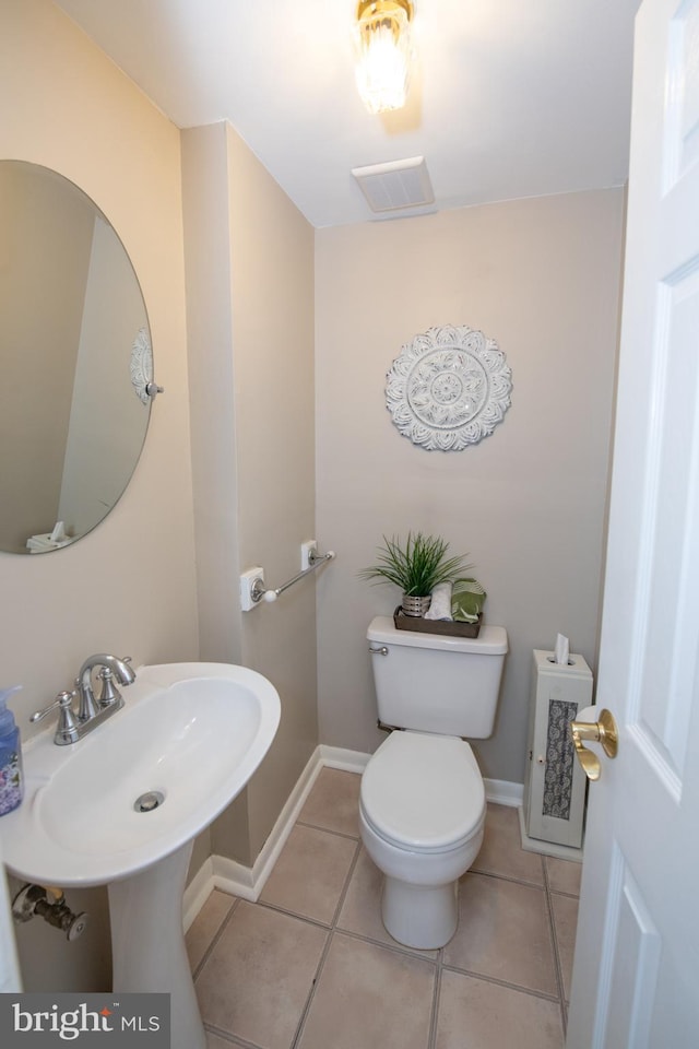 bathroom featuring toilet, visible vents, tile patterned floors, and baseboards