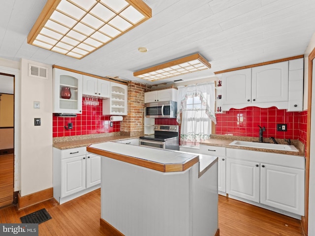 108 Delaware St, Woodbury, NJ 08096 - kitchen with stainless steel appliances, a sink, white cabinetry, light countertops, and decorative backsplash