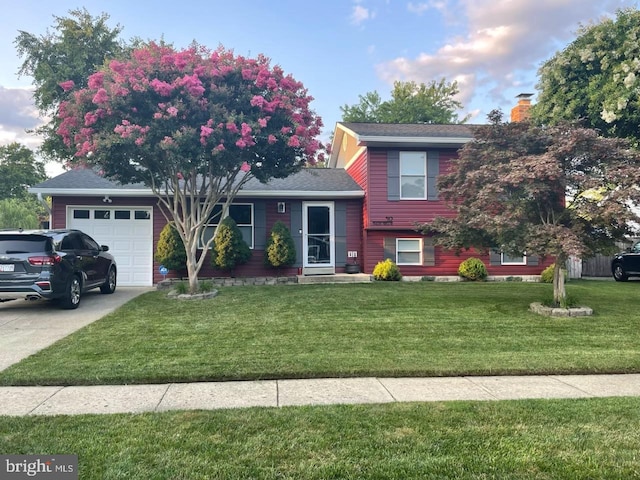 split level home with a front lawn, a shingled roof, driveway, a chimney, and an attached garage