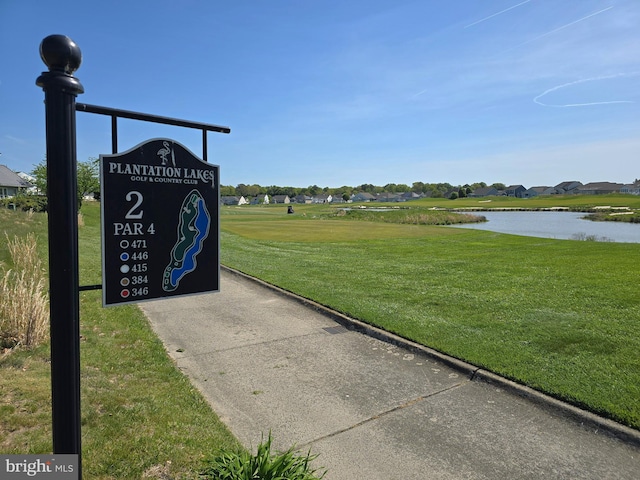 view of home's community featuring a lawn and a water view