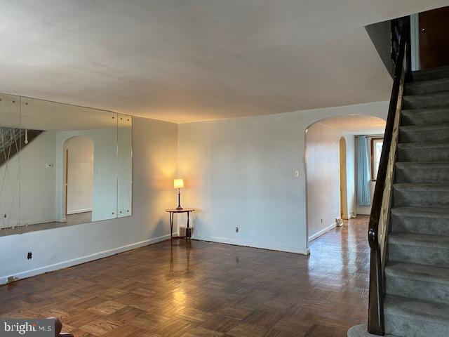 6833 E Roosevelt Blvd, Philadelphia, PA 19149 - unfurnished room with arched walkways, stairs, and baseboards