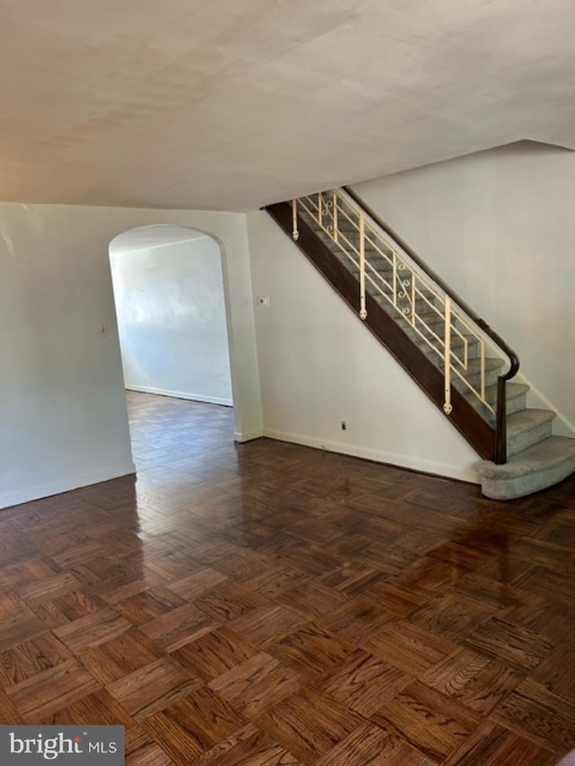 6833 E Roosevelt Blvd, Philadelphia, PA 19149 - unfurnished living room with baseboards, stairway, and arched walkways