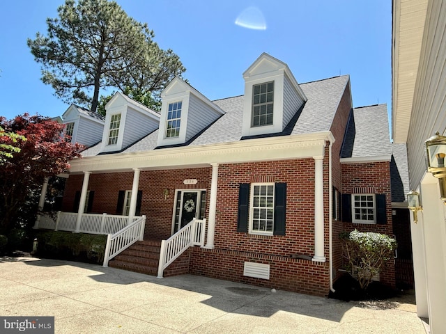 536 Yacht Club Dr, Ocean Pines, MD 21811 - cape cod home featuring brick siding, covered porch, and roof with shingles