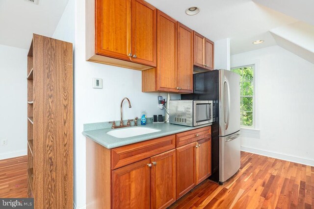 536 Yacht Club Dr, Ocean Pines, MD 21811 - kitchen with stainless steel appliances, a sink, light wood finished floors, brown cabinets, and light countertops