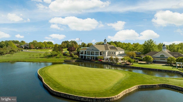 view of property's community with a water view, view of golf course, and a yard
