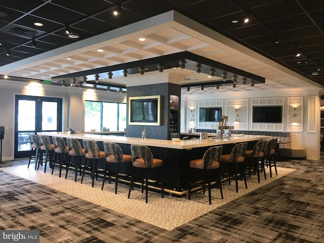 bar featuring track lighting, indoor wet bar, carpet flooring, and visible vents