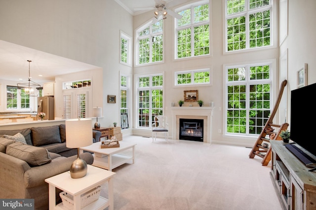 18565 Kerill Rd, Triangle, VA 22172 - living room featuring a towering ceiling, carpet, ornamental molding, ceiling fan, and plenty of natural light
