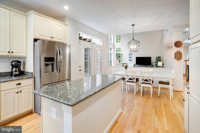 18565 Kerill Rd, Triangle, VA 22172 - kitchen with light wood-style flooring, dark stone counters, recessed lighting, stainless steel fridge with ice dispenser, and a center island