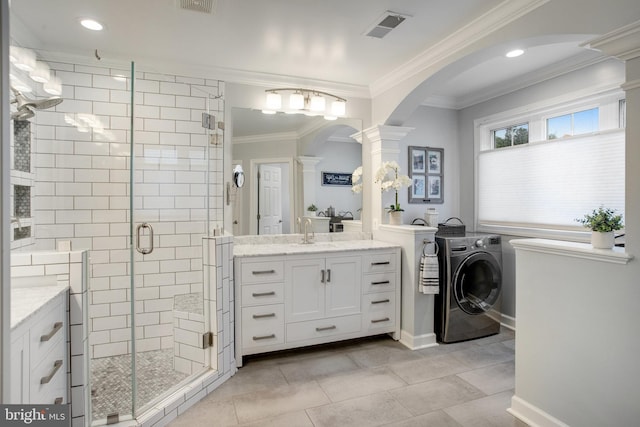18565 Kerill Rd, Triangle, VA 22172 - full bathroom with decorative columns, a shower stall, washing machine and clothes dryer, ornamental molding, and two vanities