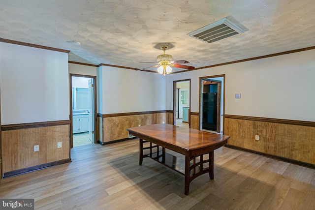 10 Mahon Cir, Ruther Glen, VA 22546 - dining area featuring a wainscoted wall, light wood finished floors, a ceiling fan, wood walls, and a textured ceiling