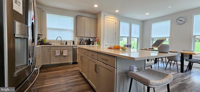 21340 Rainier Ln, Broadlands, VA 20148 - kitchen with stainless steel fridge, a breakfast bar area, gray cabinetry, dark wood-style floors, and light countertops