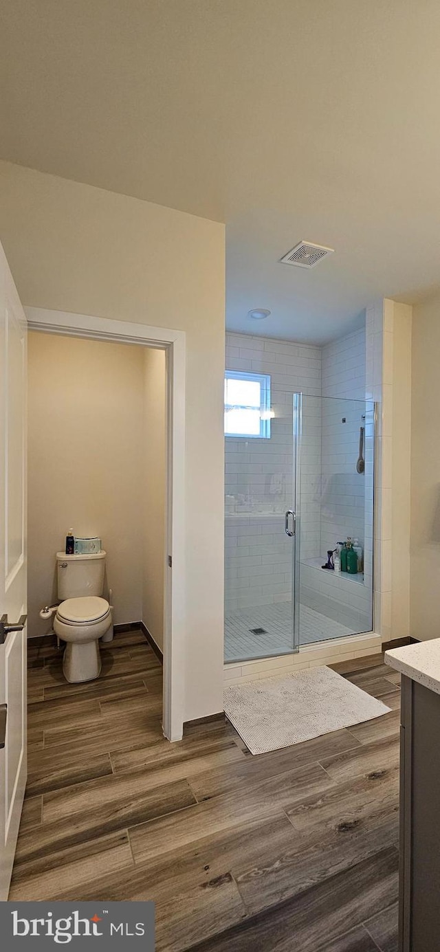 21340 Rainier Ln, Broadlands, VA 20148 - bathroom featuring wood finished floors, toilet, a stall shower, and vanity