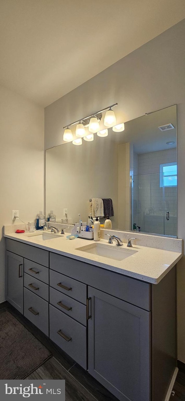 21340 Rainier Ln, Broadlands, VA 20148 - bathroom with double vanity, wood finished floors, and a shower