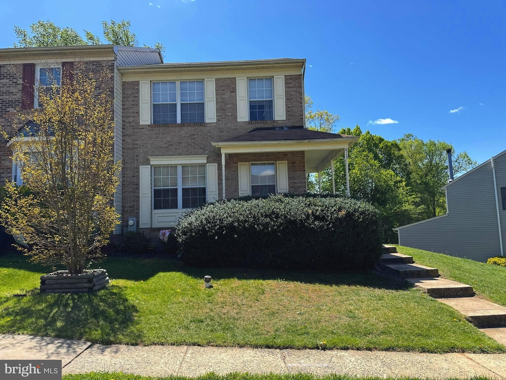 view of front of home featuring brick siding and a front lawn