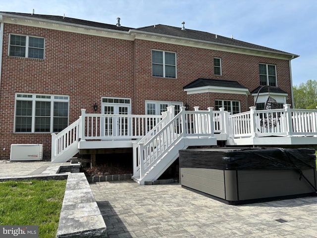 back of house with a wooden deck, a patio, stairway, and brick siding