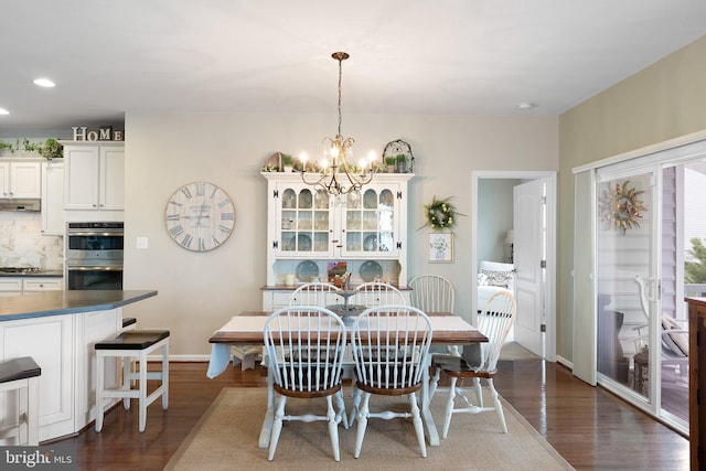 dining area featuring dark wood-style floors, recessed lighting, an inviting chandelier, and baseboards