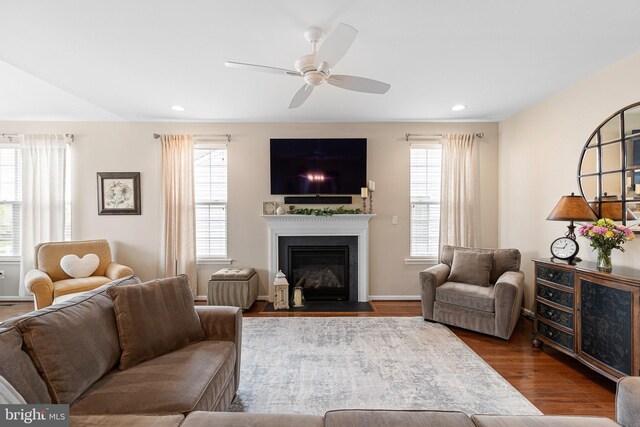 living room featuring recessed lighting, wood finished floors, ceiling fan, and a fireplace with flush hearth