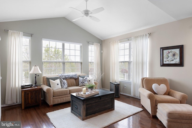 living area featuring dark wood finished floors, ceiling fan, lofted ceiling, and a healthy amount of sunlight