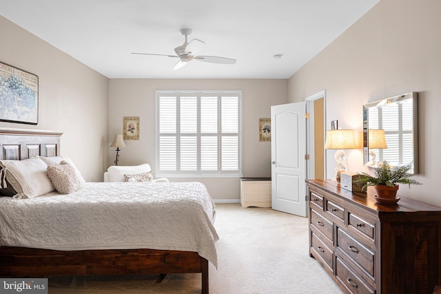 bedroom with baseboards, a ceiling fan, light carpet, and multiple windows