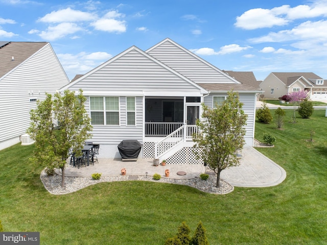 back of property featuring a yard, a patio, and a sunroom
