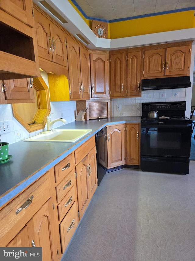 kitchen featuring under cabinet range hood, brown cabinets, tasteful backsplash, a sink, and black appliances